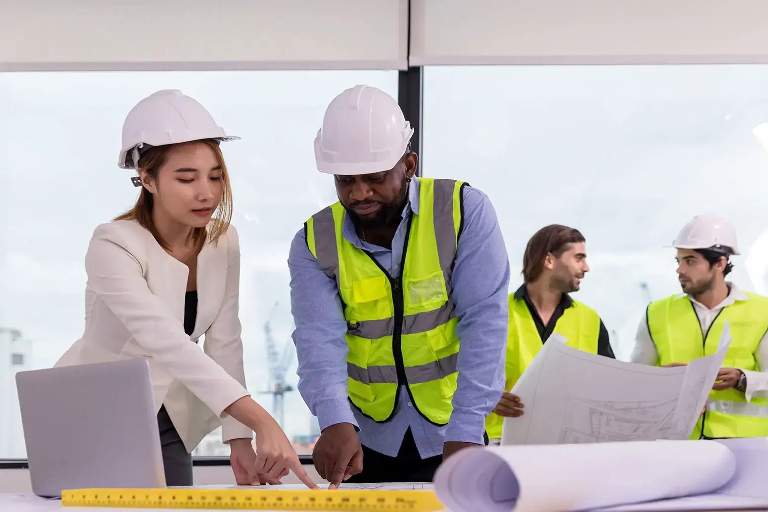 Team of engineers and contractors reviewing building plans at a construction site, representing 42 Advisory’s accounting and business advisory services for builders and trades