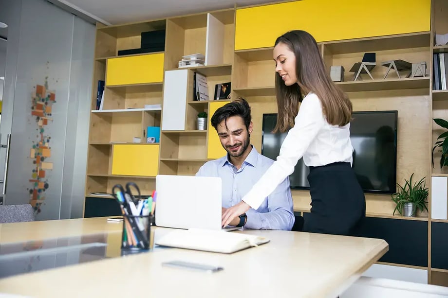 Businesswoman and businessman reviewing financial reports on laptop in a modern Melbourne office — symbolising expert accounting collaboration at 42 Advisory.