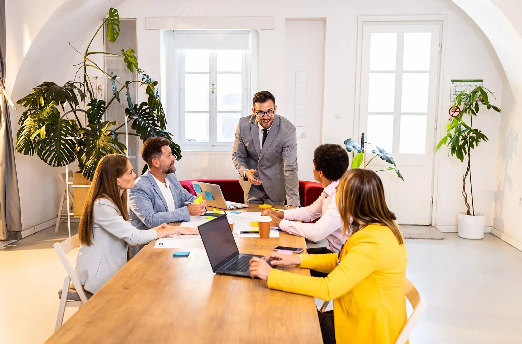 Group of business professionals meeting around a conference table in a bright office — reflecting business accounting and advisory services by 42 Advisory in Melbourne.