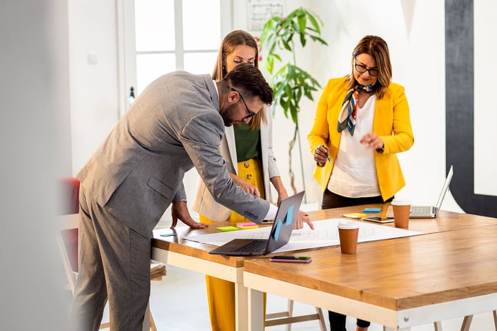 eam of Melbourne business professionals collaborating around a laptop in a modern office — representing 42 Advisory’s collaborative approach to accounting and business advisory services