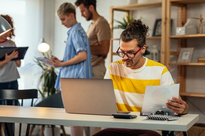 Young entrepreneurs collaborating in a modern office, planning business strategy on laptops — representing startup accounting, growth advisory, and financial planning services by 42 Advisory in Melbourne